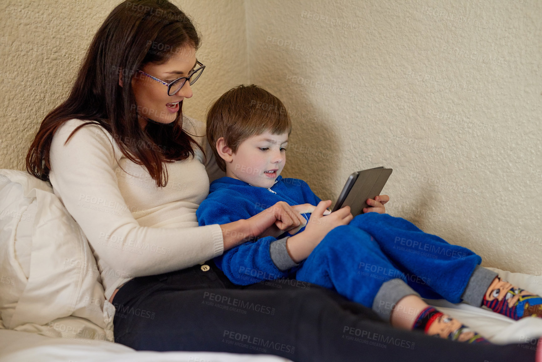 Buy stock photo Mother, child and tablet in home bedroom for learning, education and storytelling with boy online. Mom, kid and digital tech on bed for game, relax or family streaming cartoon on internet together