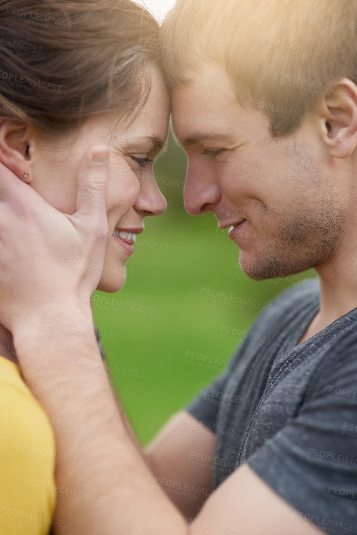 Buy stock photo Shot of a loving couple showing each other affection outside