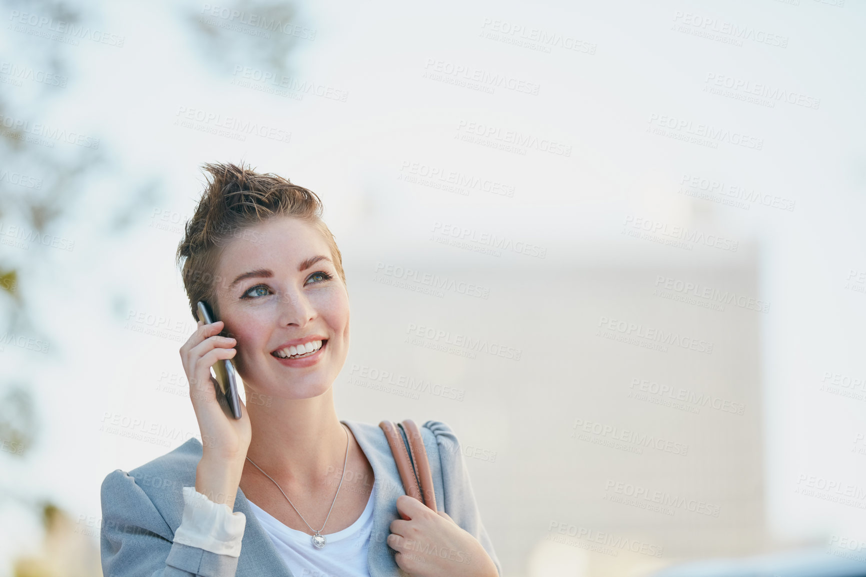 Buy stock photo Cropped shot of a young businesswoman talking on her cellphone while out in the city