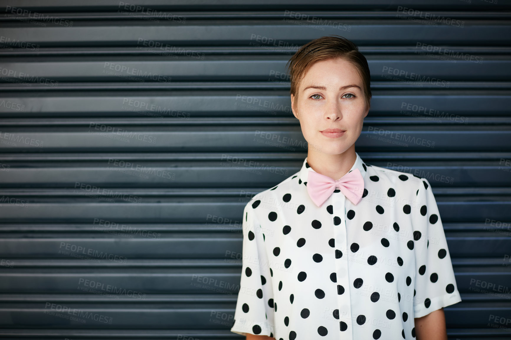 Buy stock photo Portrait of a trendy young woman standing against a corrugated background