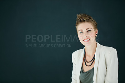 Buy stock photo Portrait of a young businesswoman posing against a black background