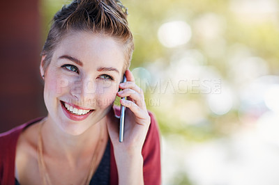 Buy stock photo Shot of an attractive young businesswoman using her cellphone while standing on her office balcony