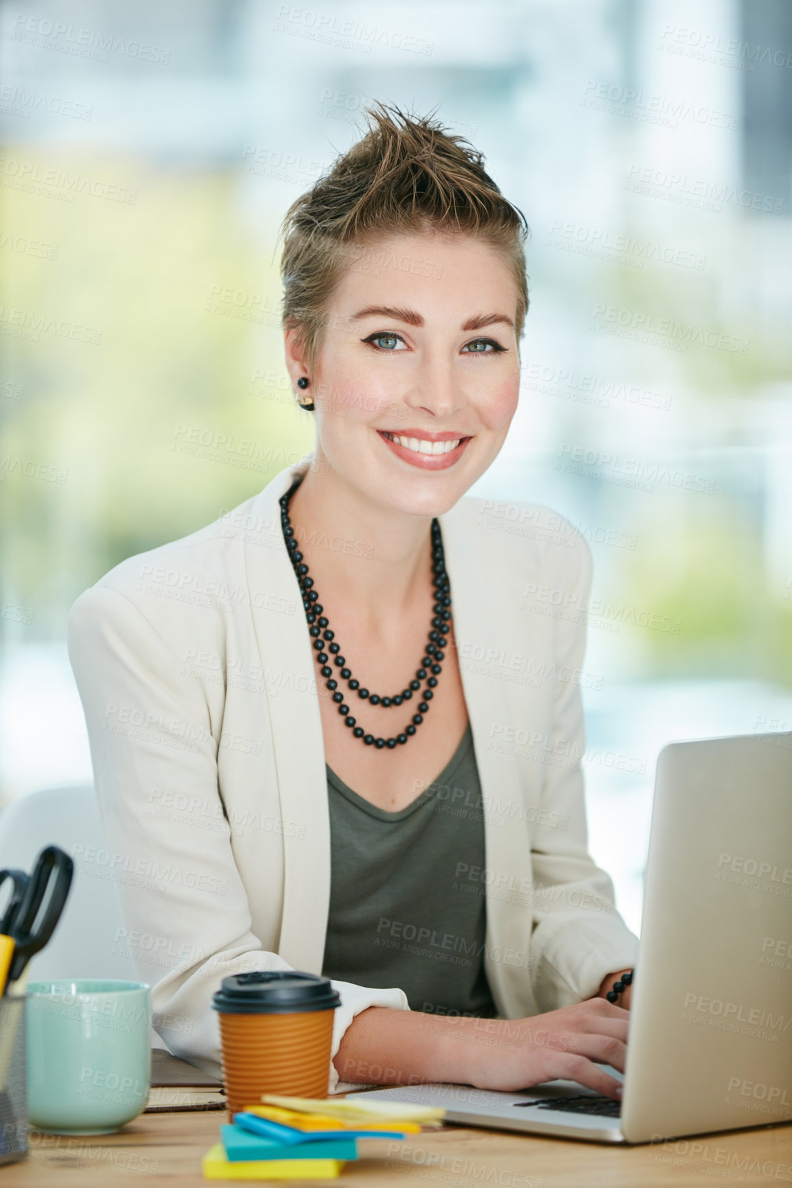 Buy stock photo Portrait of a young businesswoman working on a laptop in an office