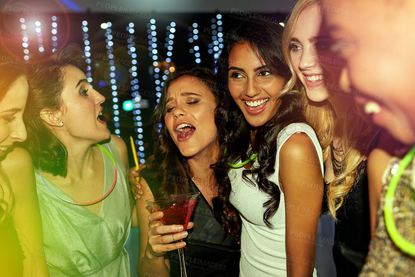 Buy stock photo Shot of a group of young people enjoying themselves at a nightclub