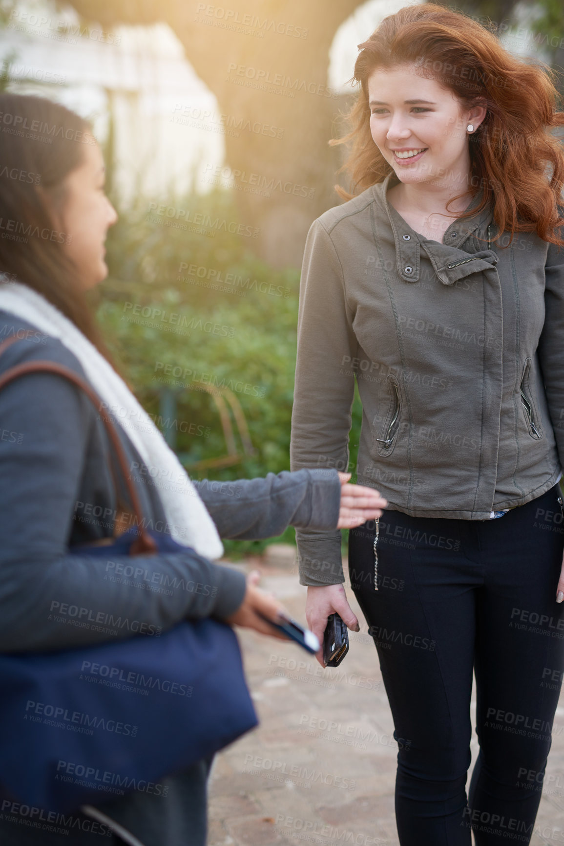 Buy stock photo Cropped shot of two young women chatting outside
