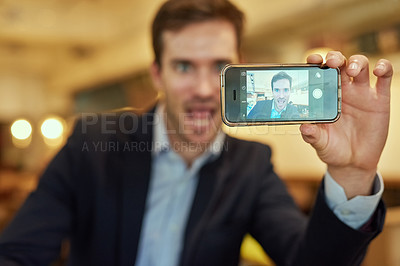 Buy stock photo Shot of a young businessman taking a selfie while sitting in a coffee shop