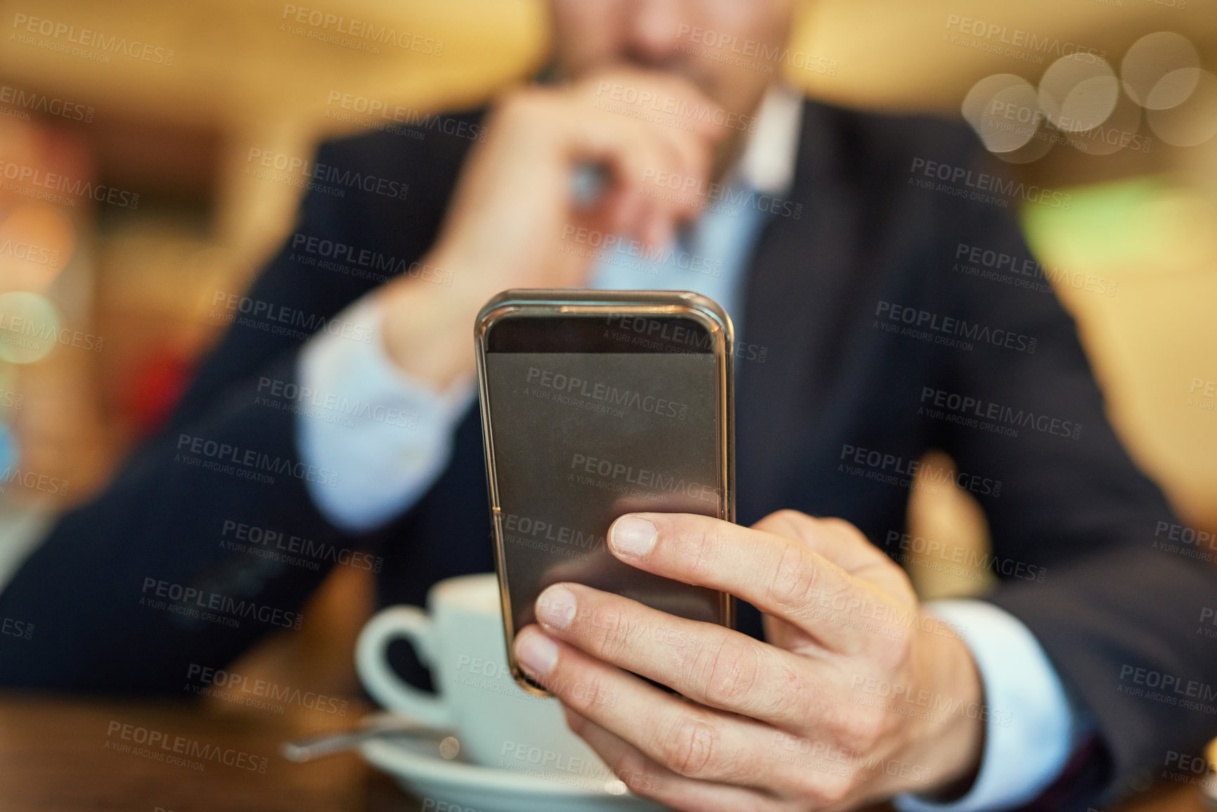 Buy stock photo Shot of an unrecognizable businessman sending a text message while sitting in a coffee shop