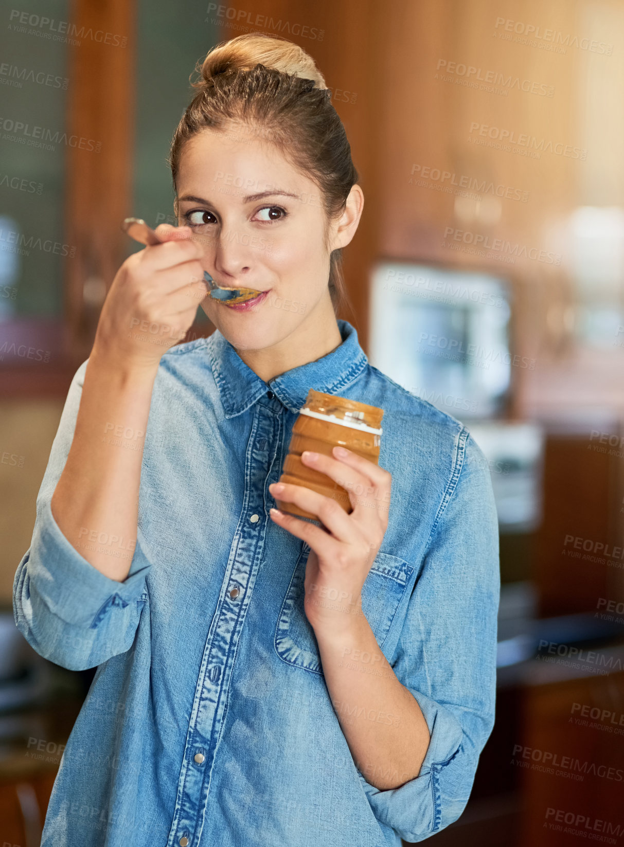 Buy stock photo Woman, container and eating peanut butter in kitchen with spoon, happiness and nutrition in home. Female person, health and vegan diet in apartment for vitamins, sustainability and energy in morning