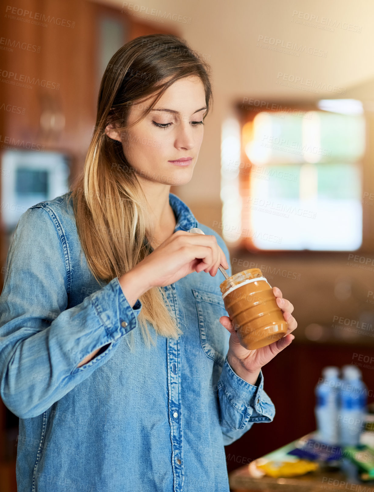 Buy stock photo Home, woman and peanut butter in kitchen for eating, snack and nutrient with spoon indoors. House, proteins and vitamins in plastic container, product and natural with ingredients in morning