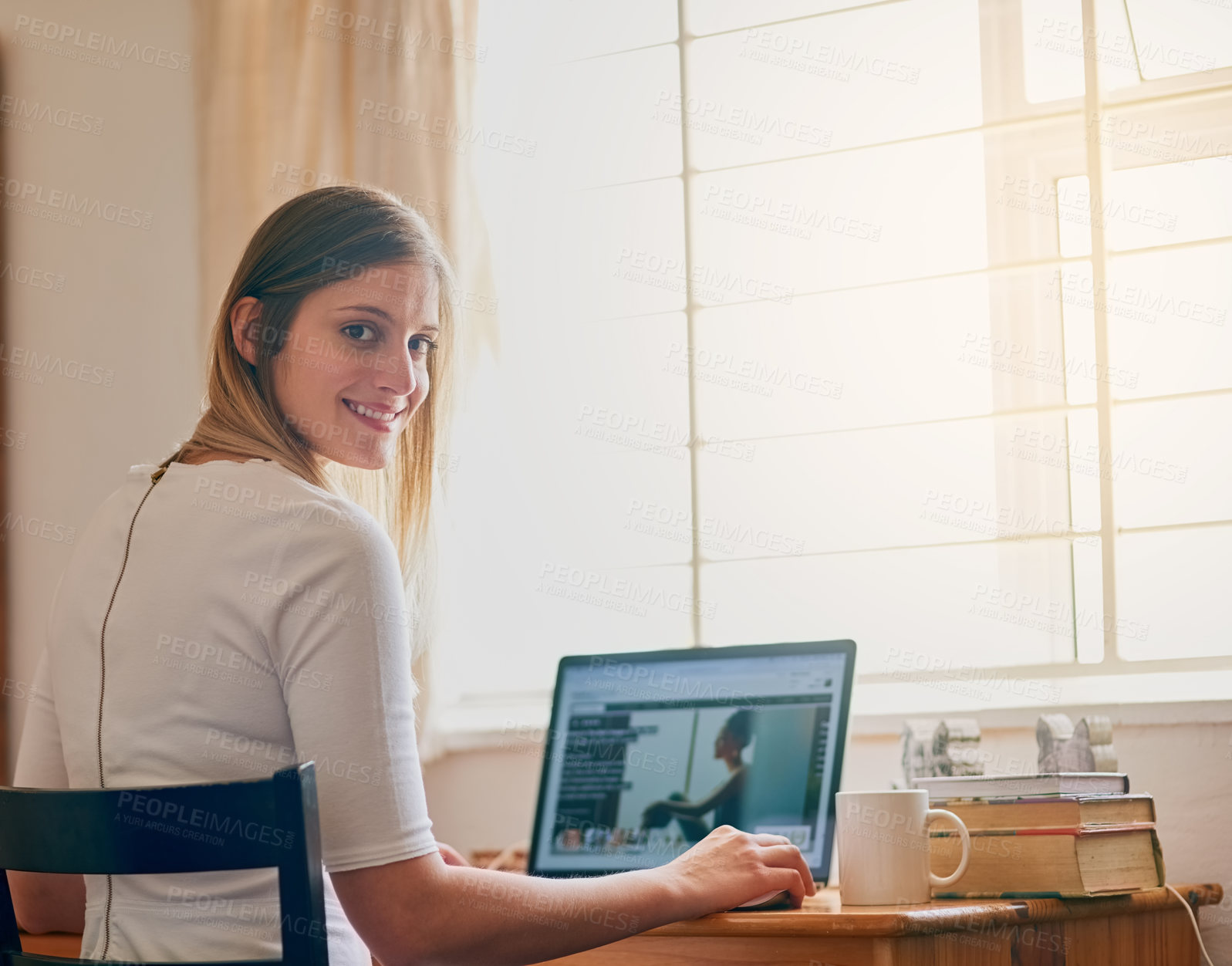 Buy stock photo Portrait of a young woman using her laptop at her desk at home