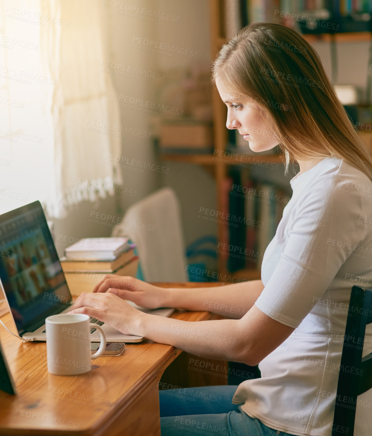 Buy stock photo Shot of a young woman using her laptop at her desk at home