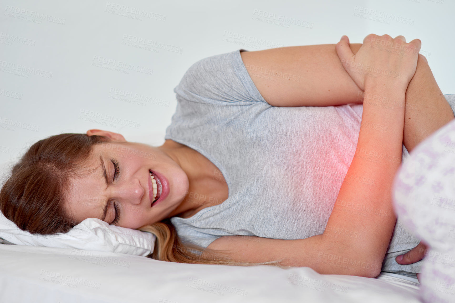 Buy stock photo Cropped shot of a young woman experiencing stomach pain highlighted in glowing red