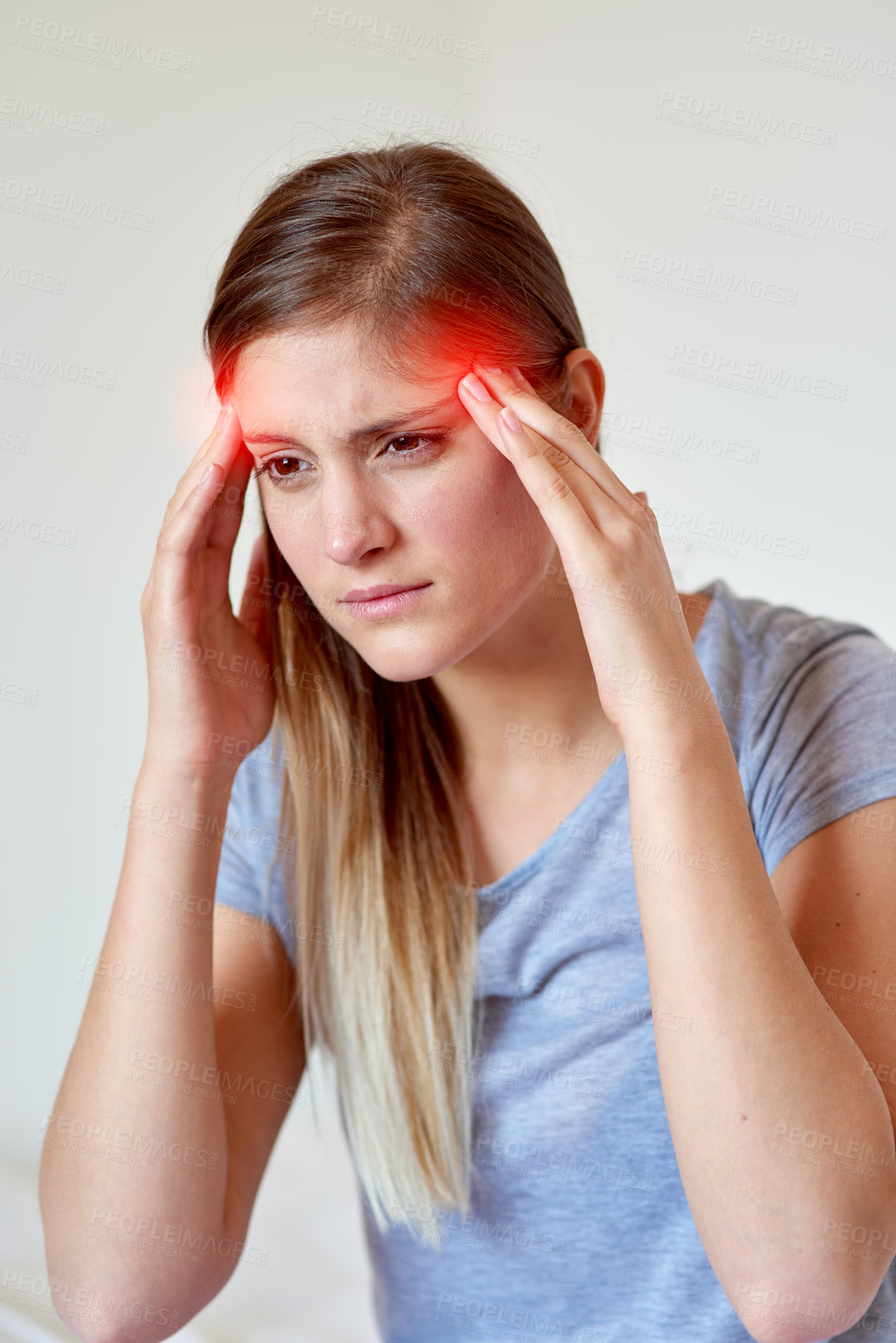 Buy stock photo Cropped shot of a young woman suffering from a headache highlighted in glowing red