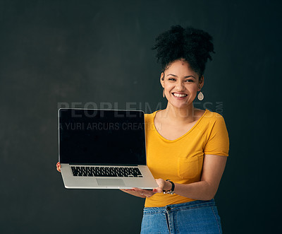 Buy stock photo Shot of a young woman holding a laptop against a grey background
