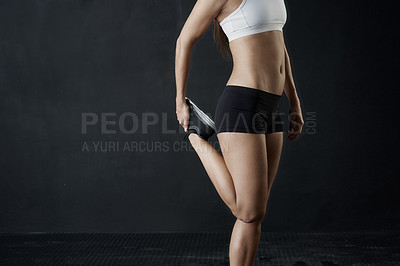 Buy stock photo Studio shot of an unrecognizable woman warming up against a dark background