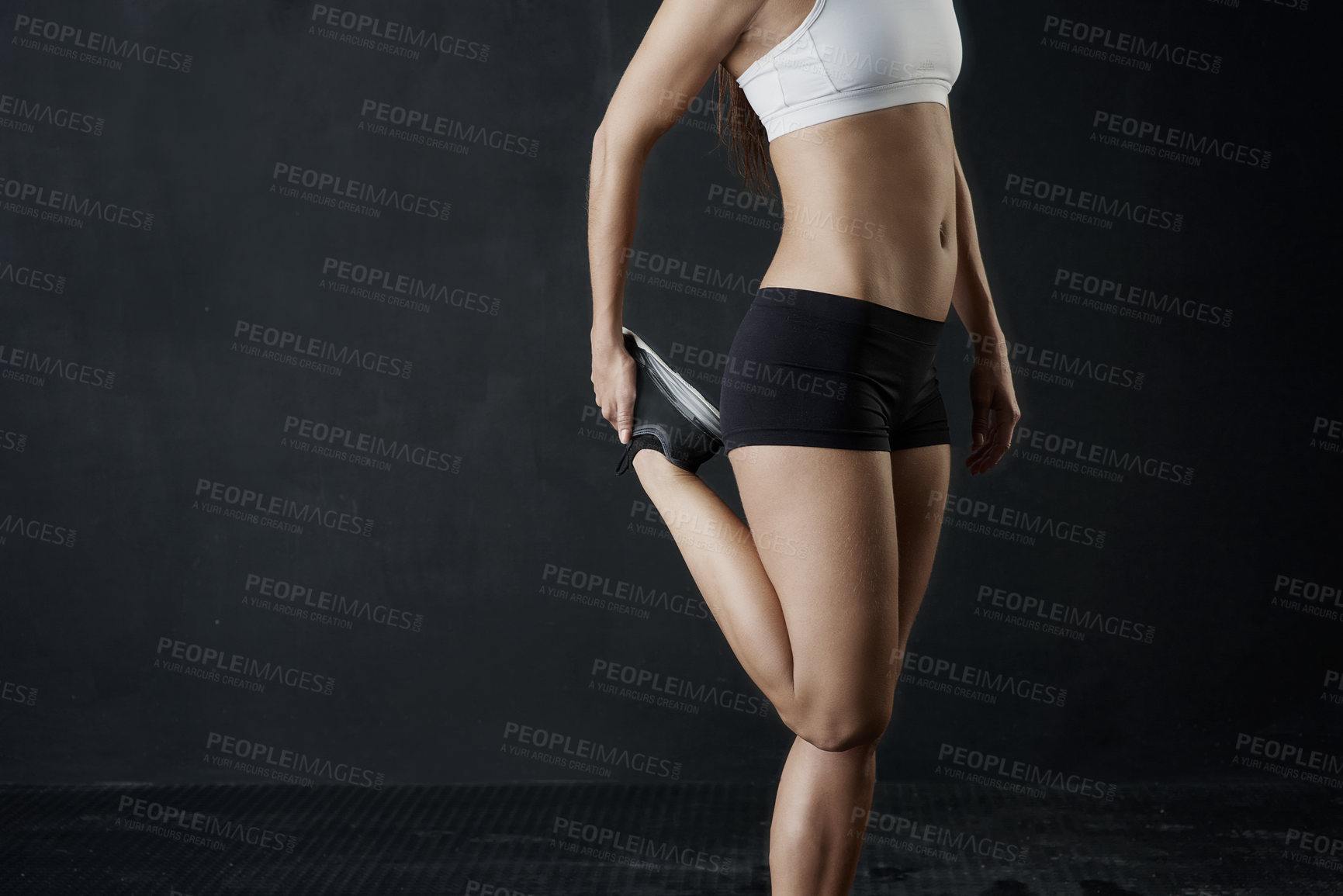 Buy stock photo Studio shot of an unrecognizable woman warming up against a dark background