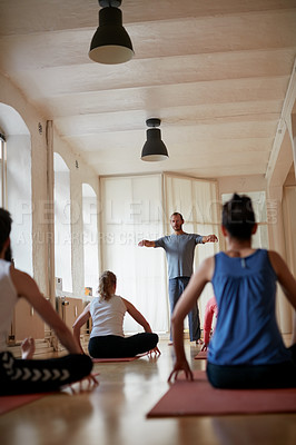 Buy stock photo Rearview shot of a yoga instructor leading his class in a yoga routine