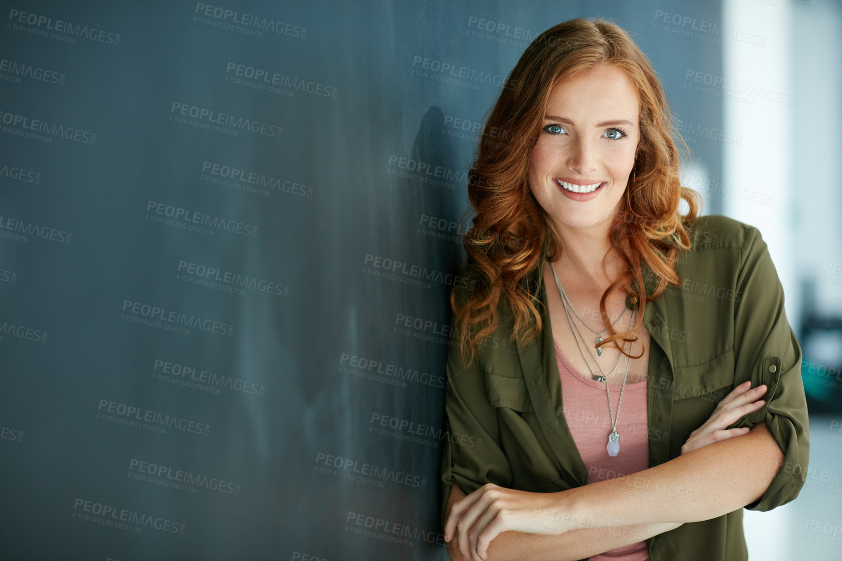 Buy stock photo Portrait of a confident young woman leaning against a blackboard