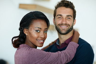 Buy stock photo Portrait of a young business couple hugging each other in an office