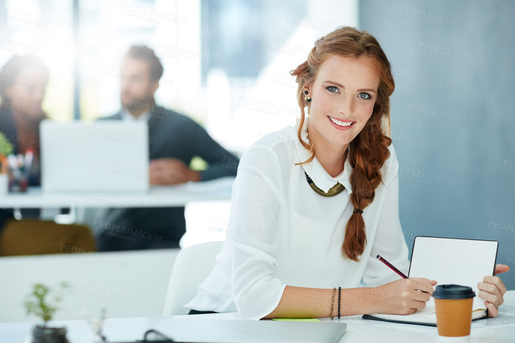 Buy stock photo Portrait of a young businesswoman working in an office with colleagues in the background