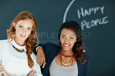 Buy stock photo Portrait of two young businesswomen standing together in an office