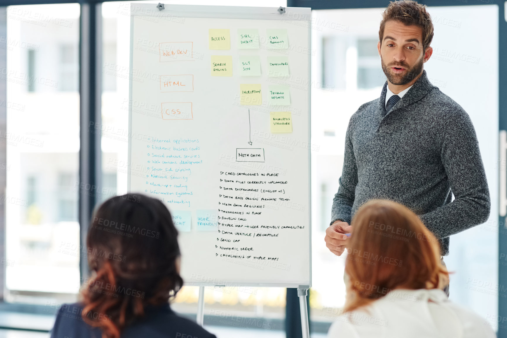 Buy stock photo Cropped shot of a young businessman giving a presentation to his colleagues in an office