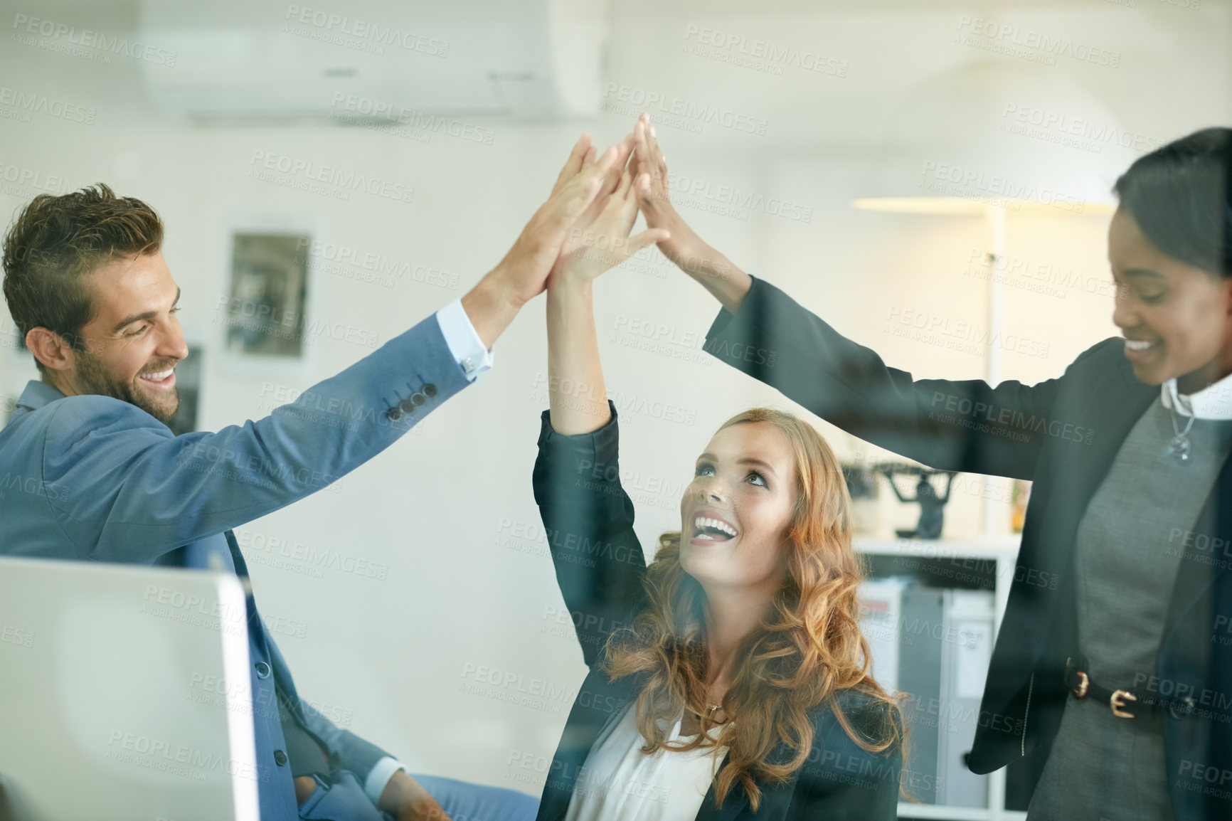 Buy stock photo Cropped shot of colleagues high fiving together in an office