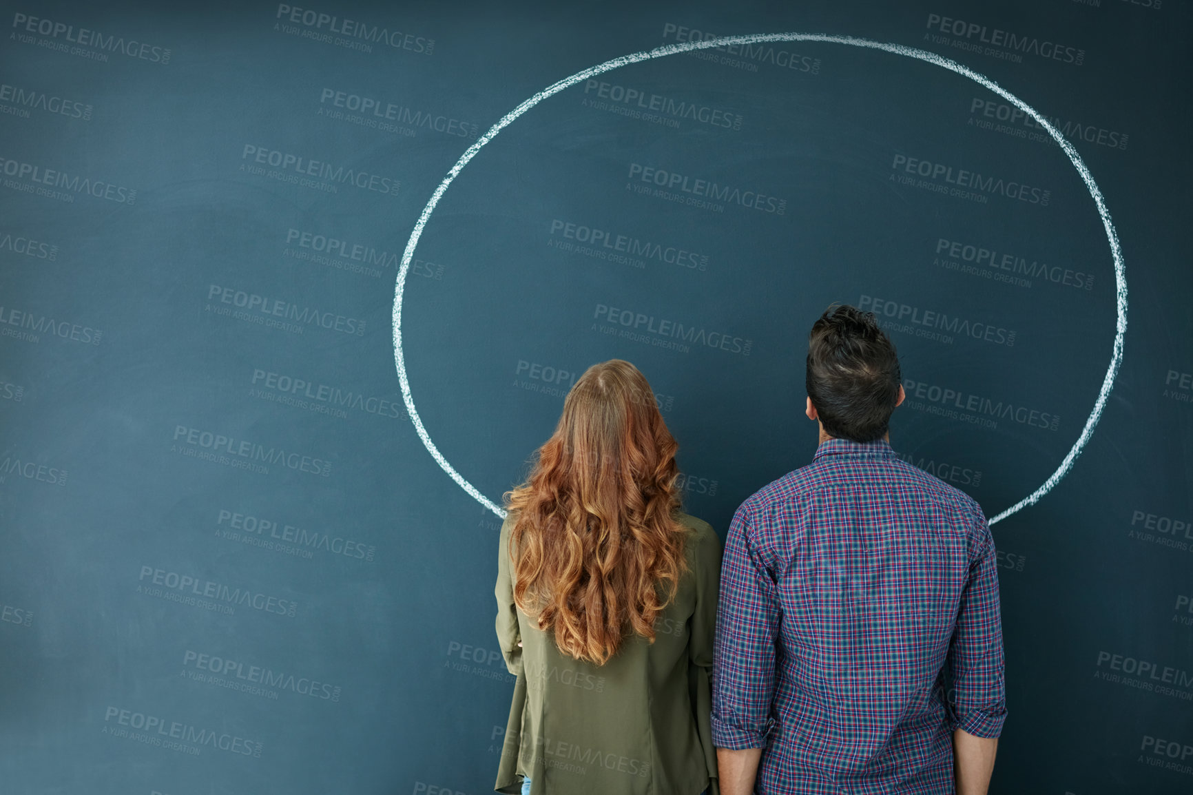 Buy stock photo Rearview shot of a young couple looking at an empty circle drawn on a blackboard