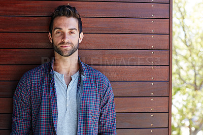Buy stock photo Portrait of a handsome man standing against a wooden wall