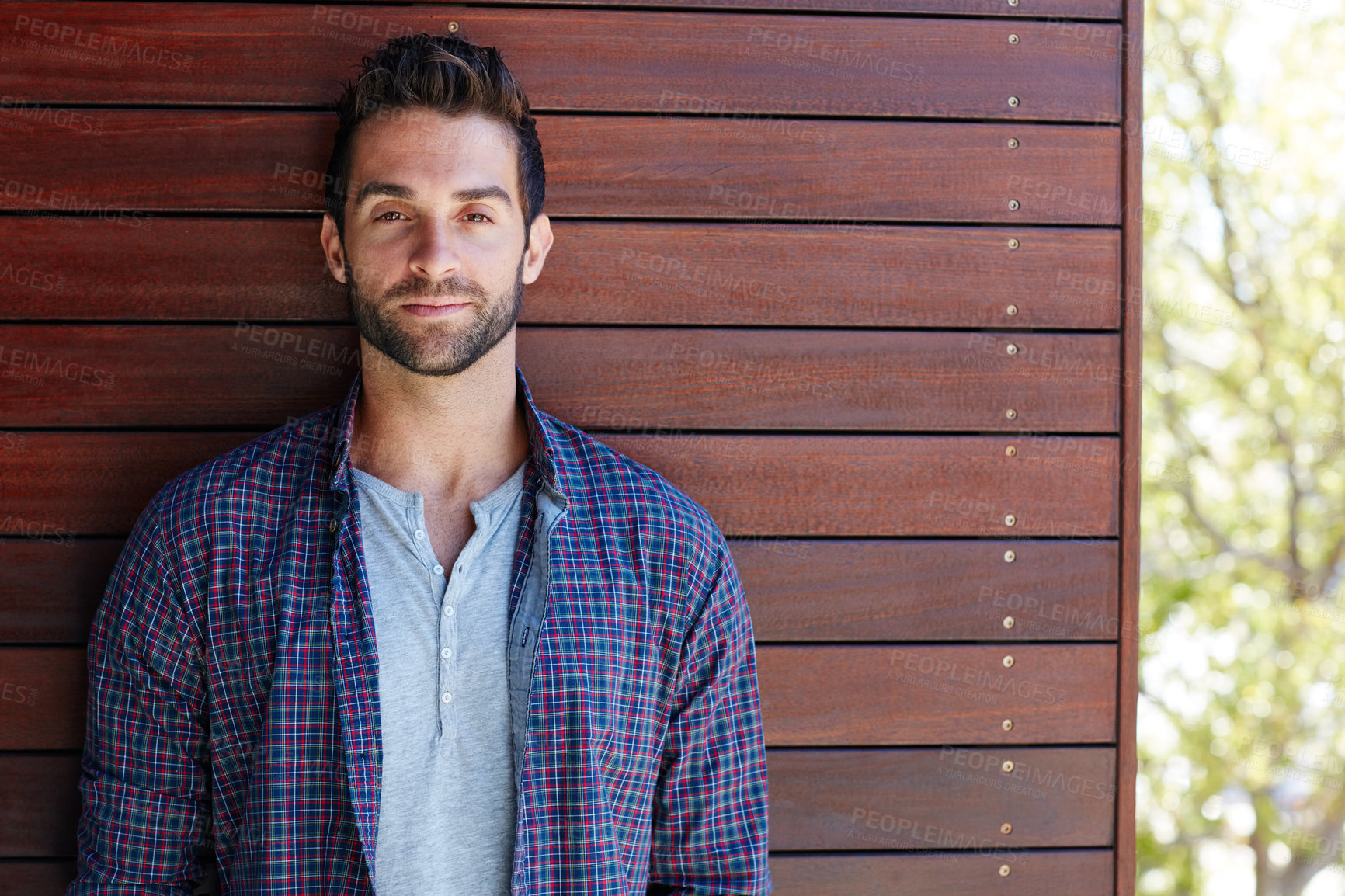 Buy stock photo Portrait of a handsome man standing against a wooden wall