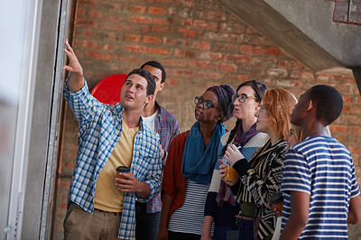 Buy stock photo Cropped shot of a group of university students looking at a notice on a wall