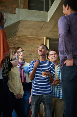 Buy stock photo Cropped shot of a group of university students socialising on campus