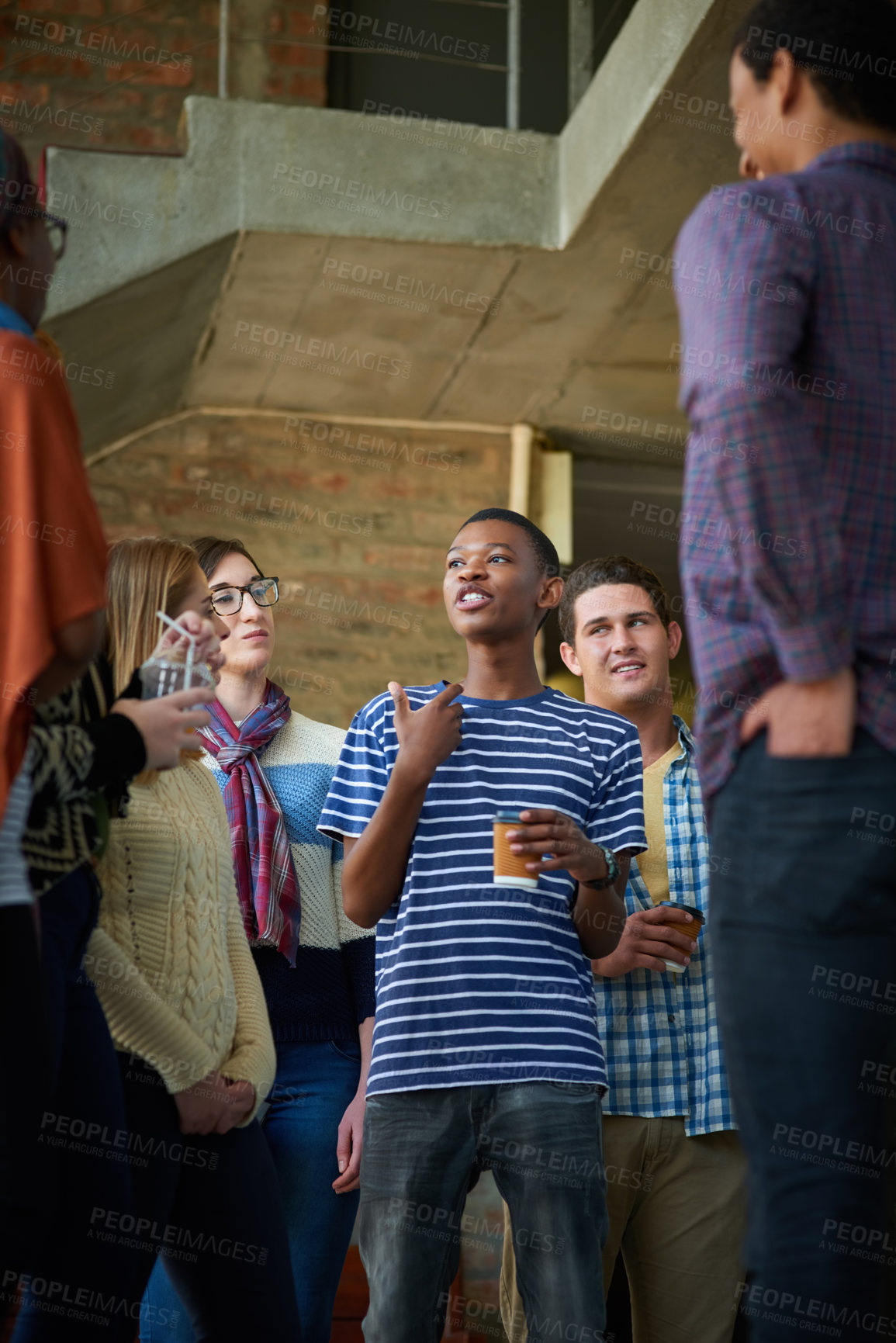 Buy stock photo Cropped shot of a group of university students socialising on campus