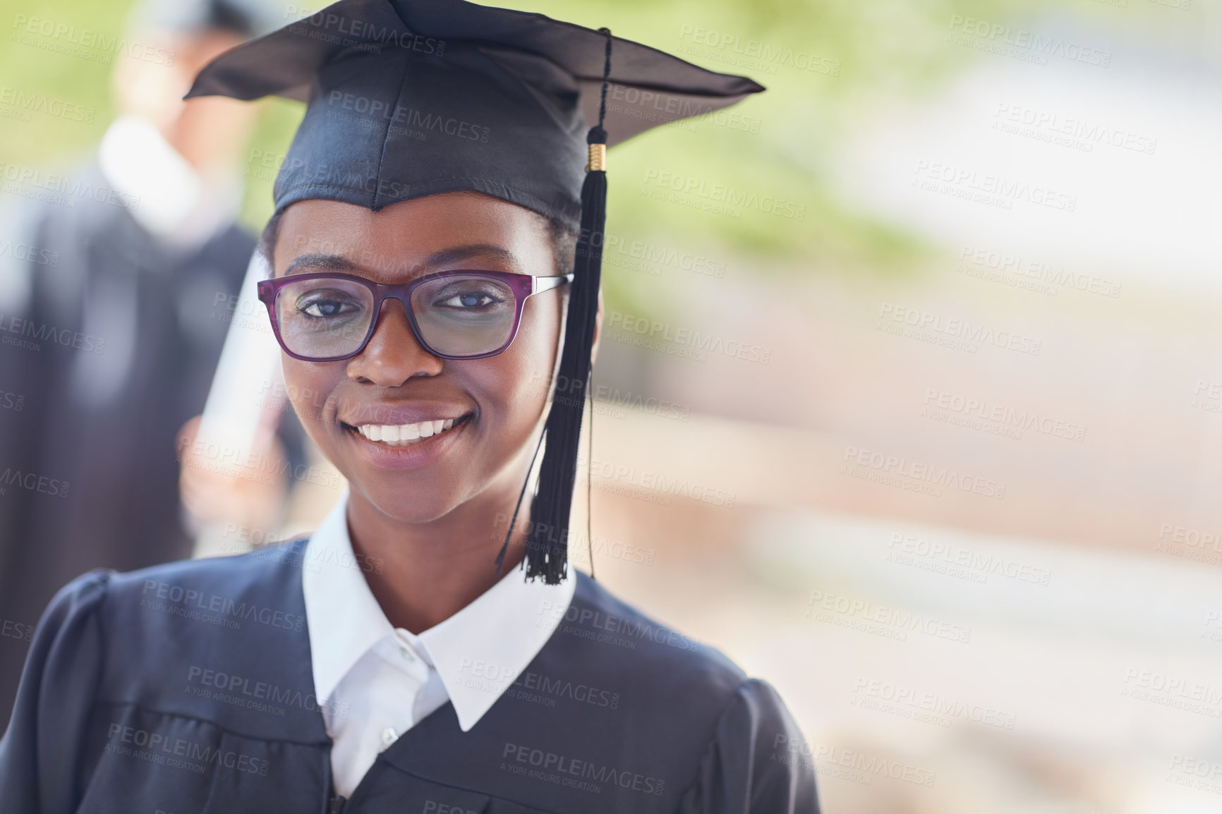 Buy stock photo Portrait of a happy female student standing outside on her graduation day