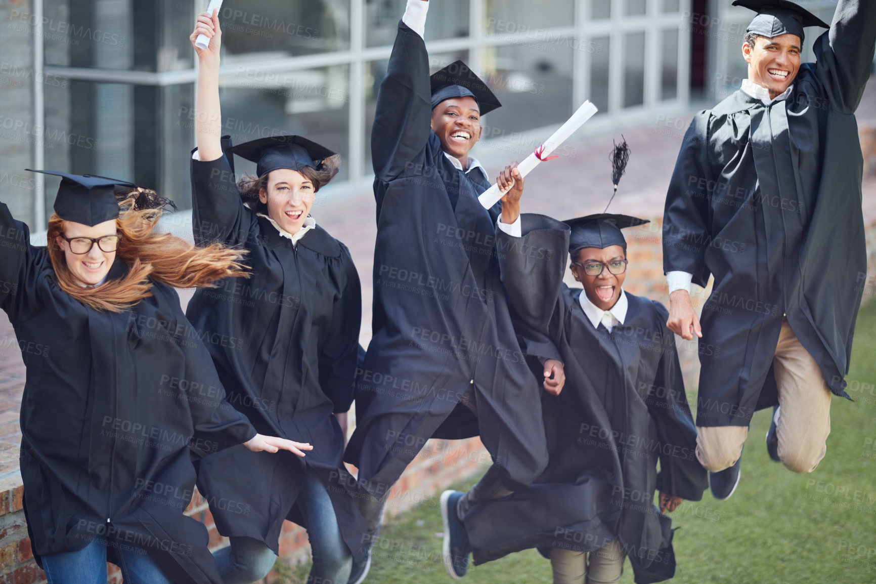 Buy stock photo High angle shot of a happy group of students jumping in celebration on graduation day