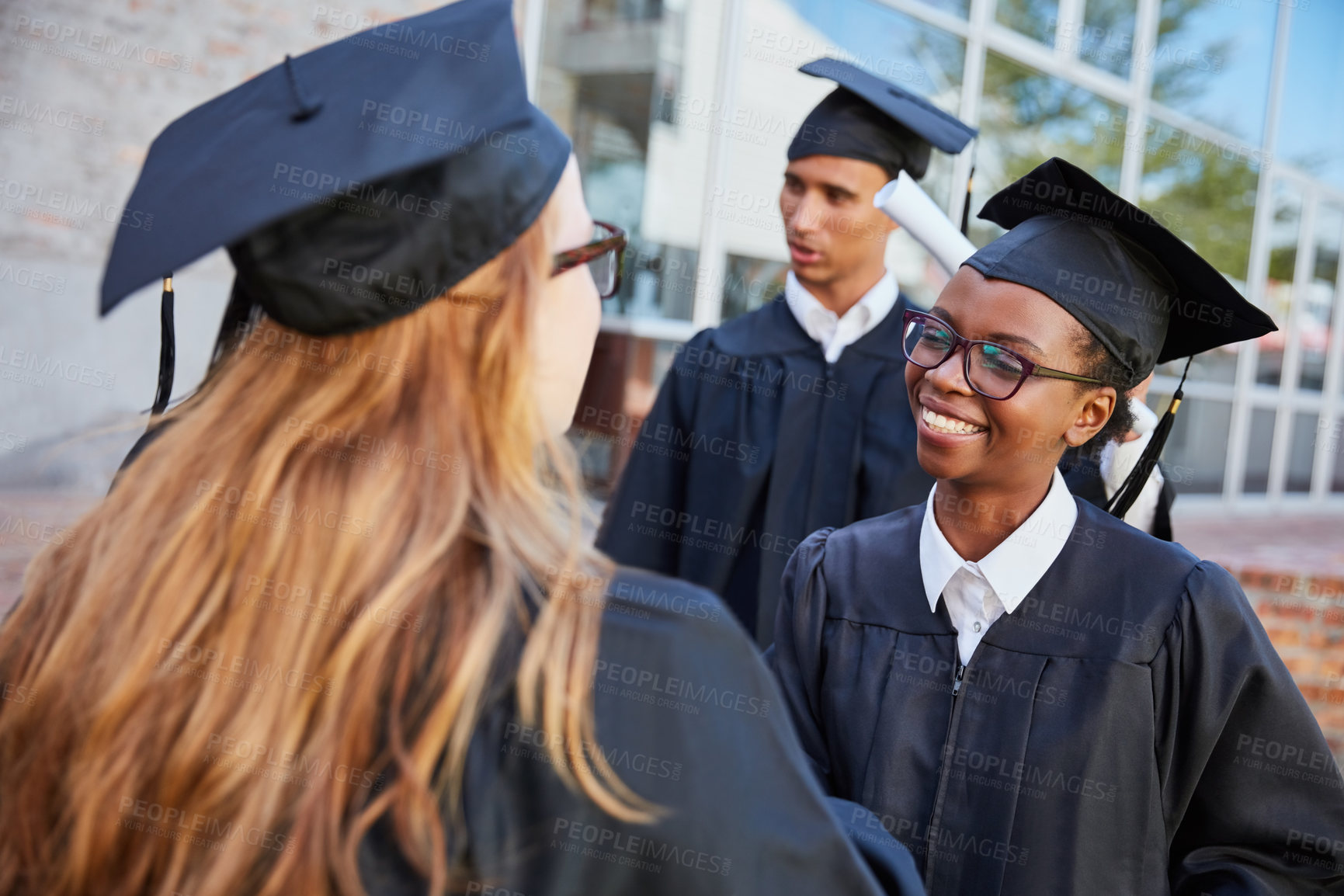 Buy stock photo Shot of two female students congratulating each other on graduation day