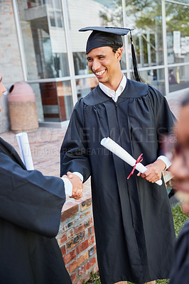 Buy stock photo Shot of two male students congratulating each other on graduation day