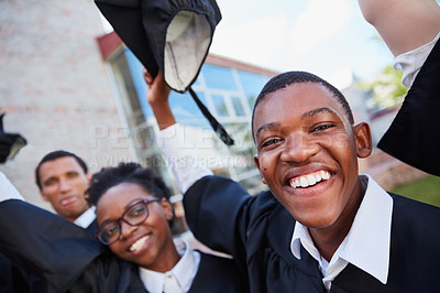 Buy stock photo Portrait of a happy group of students standing outside on their graduation day