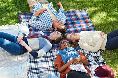 Buy stock photo Shot of a group of young friends relaxing outside on campus