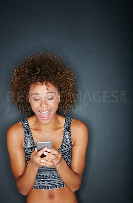 Buy stock photo Studio shot of a happy woman looking at her phone