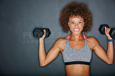 Buy stock photo Studio shot of a fit young woman lifting weights against a grey background