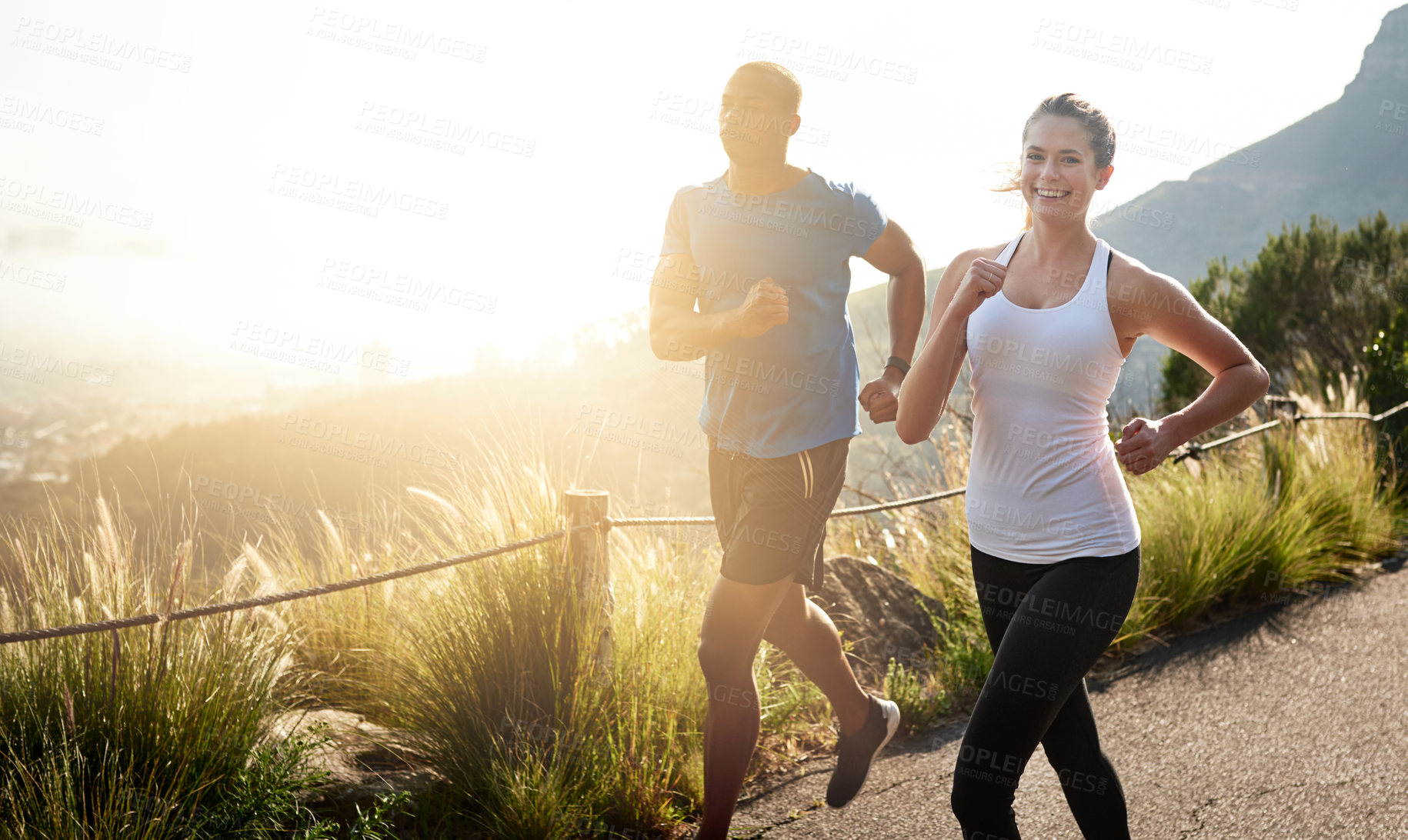 Buy stock photo Shot of a sporty couple out running on a mountain road