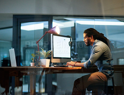 Buy stock photo Cropped shot of a young designer working late on a computer in an office