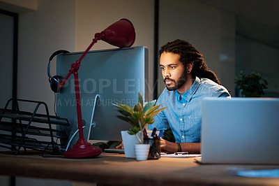 Buy stock photo Cropped shot of a young designer working late on a computer in an office