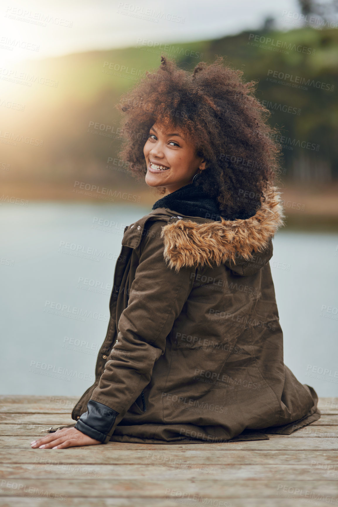 Buy stock photo Woman, happy and portrait on pier by lake, afro and travel for vacation, nature and outdoor in sunshine. Girl, person and sitting on jetty for view of river, water and morning on holiday in Brazil