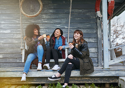 Buy stock photo Shot of a group of friends sitting on the porch of a fishing cabin together