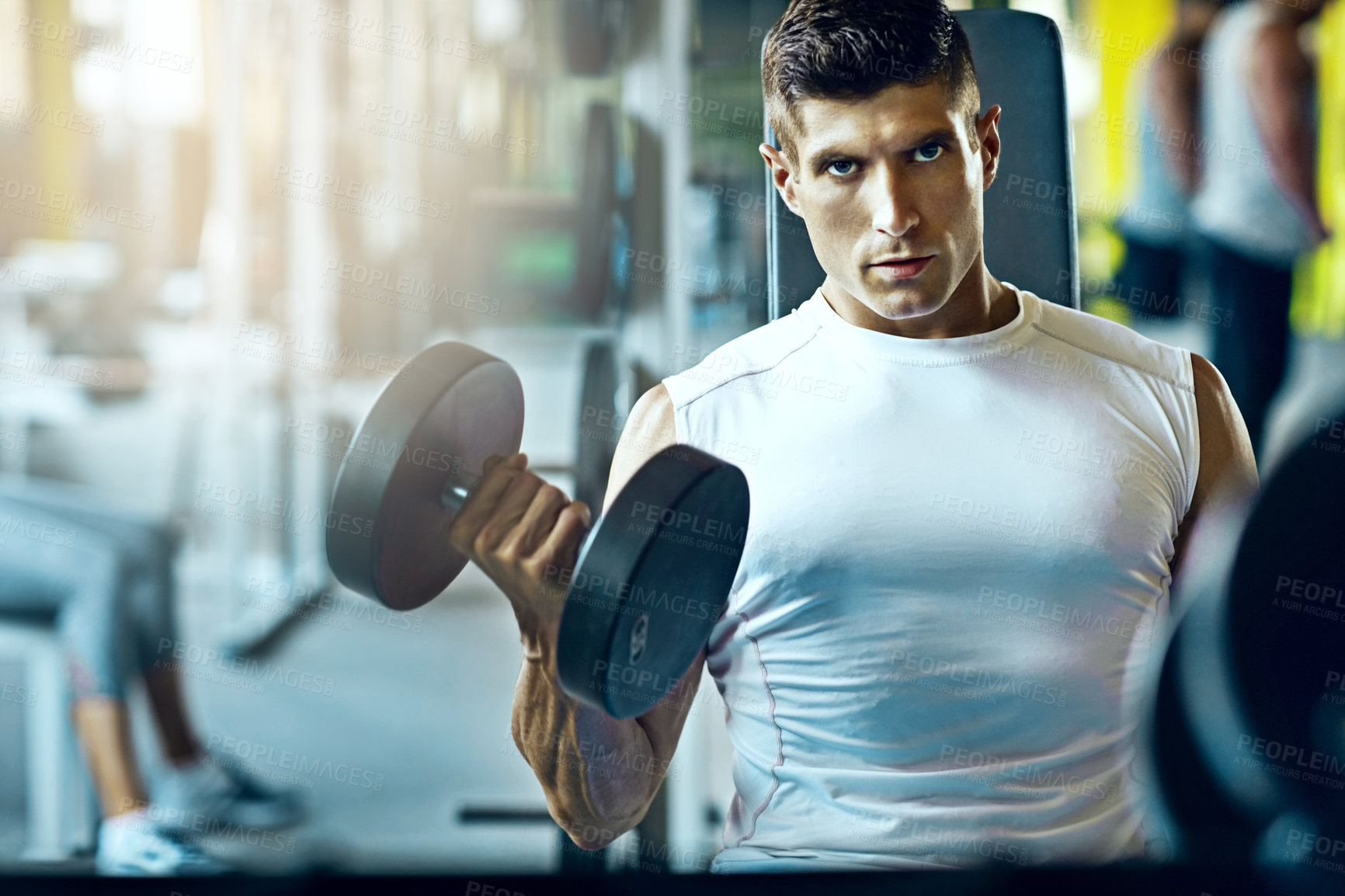 Buy stock photo Shot of a young man working out alone in the gym