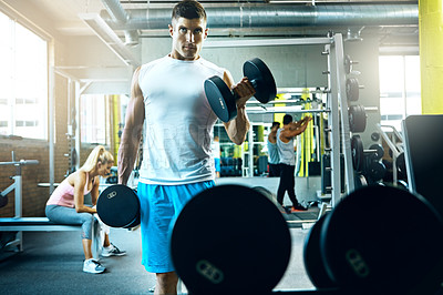 Buy stock photo Shot of a young man working out alone in the gym