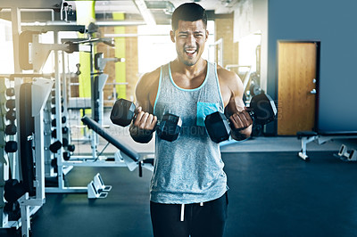 Buy stock photo Shot of a young man working out alone in the gym