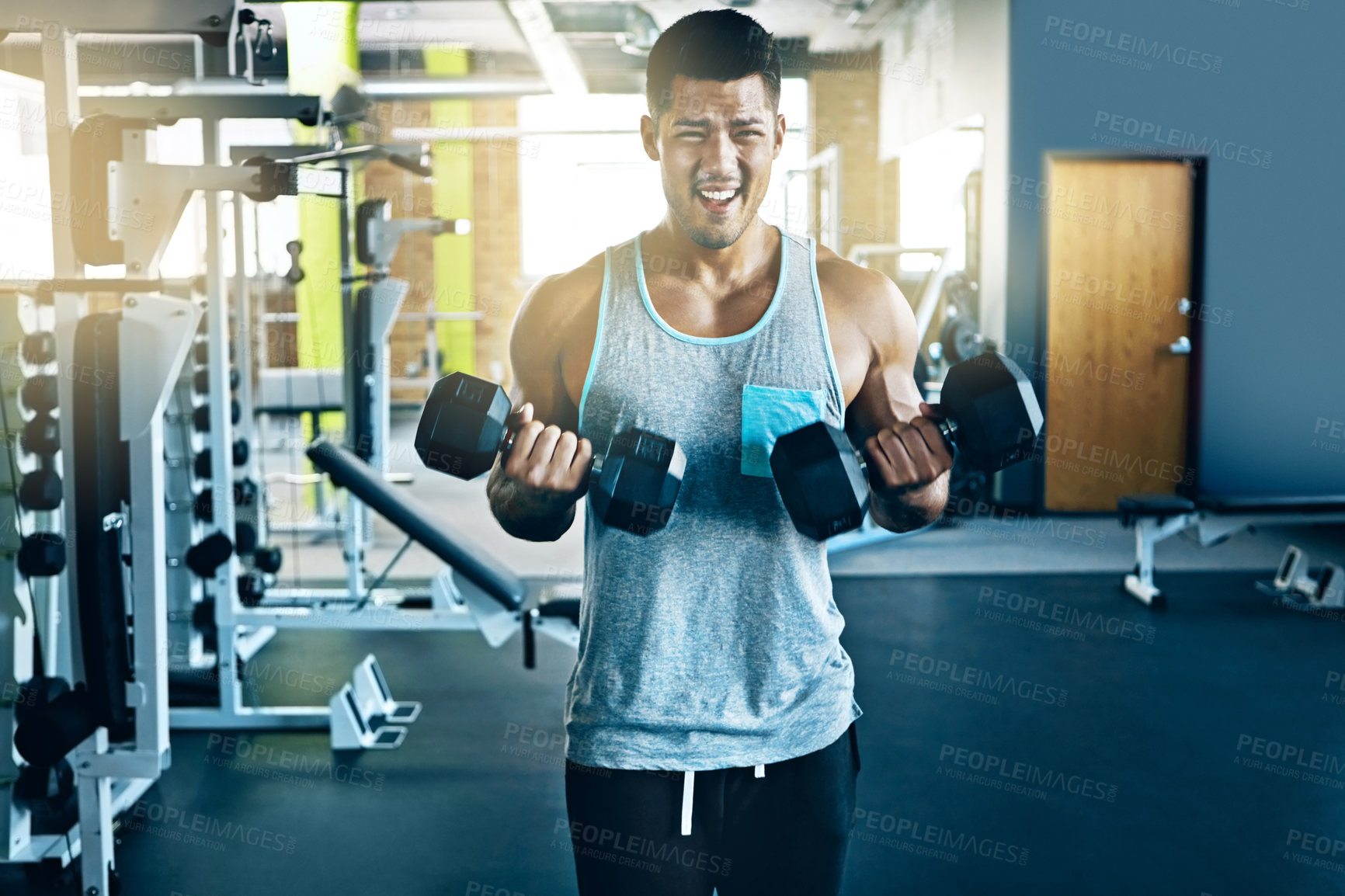 Buy stock photo Shot of a young man working out alone in the gym